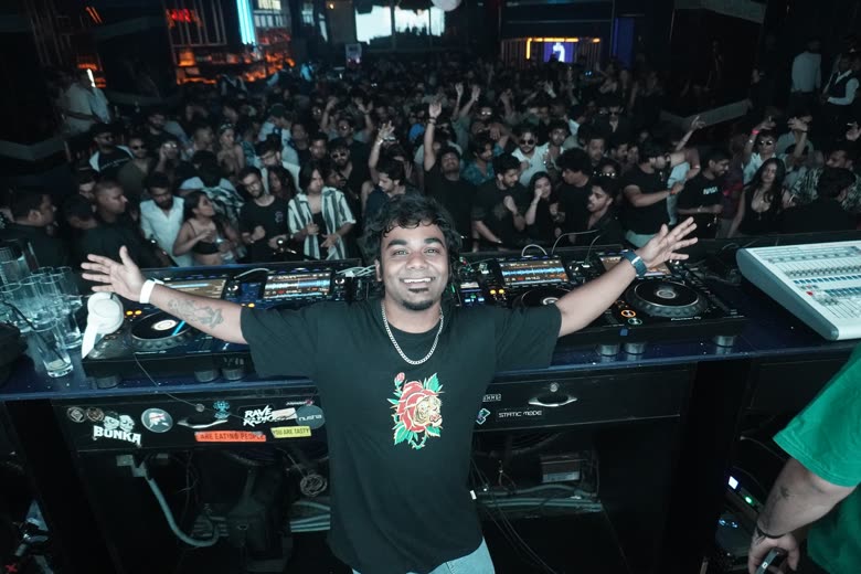 Protonix behind the decks in front of a packed club crowd